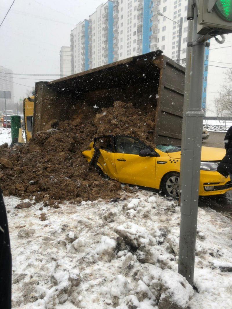 Груженный песком КамАЗ опрокинулся на такси в Москве
