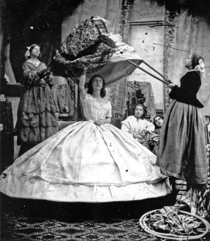 Служанки надевают платье на даму в кринолине, 1860–е годы